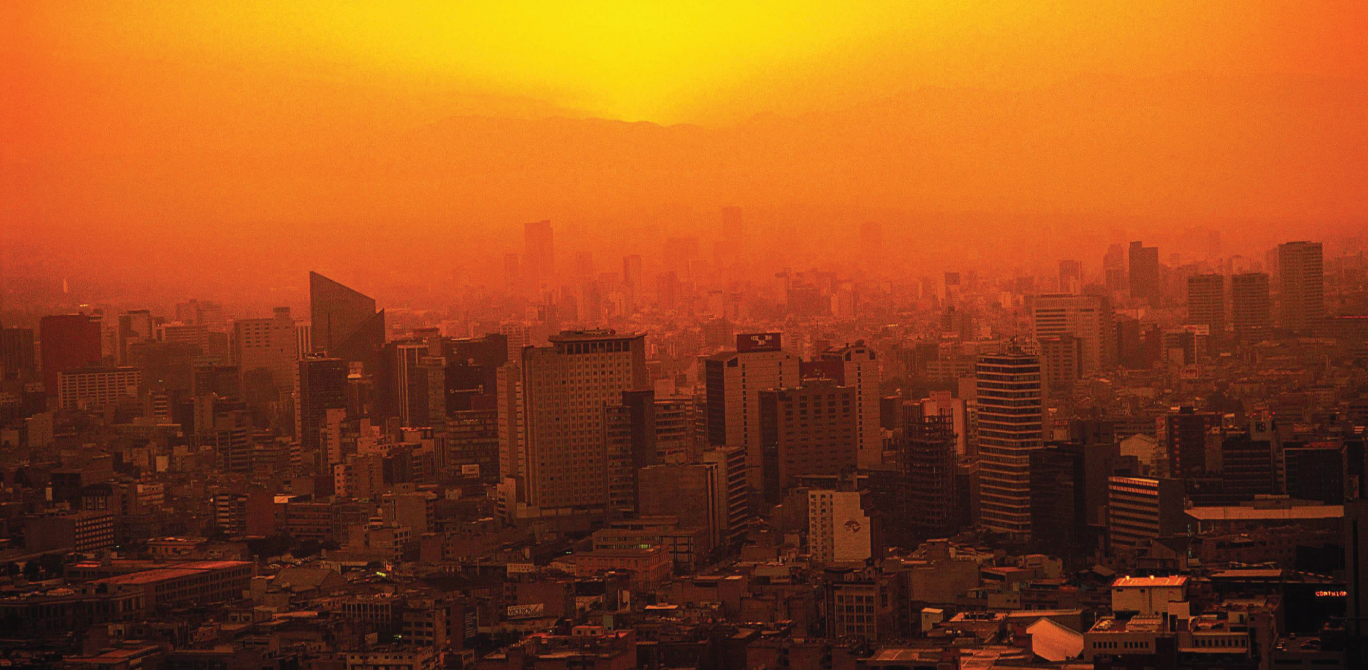 Orange tinted image of a city with sun and heat over it